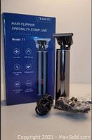 Photo showing Teamyo T1 hair clipper, original blue box with product features, charging cable, and several guide combs wrapped in plastic.