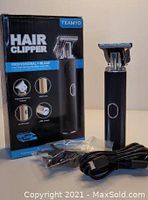 Photo showing Teamyo wireless professional T-blade hair clipper with box, USB charging cable, and several clipper guards on a plain surface.
