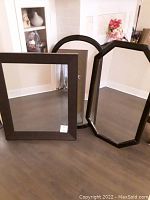 Three dark wood framed wall mirrors: one square, one octagonal, one arch-top.