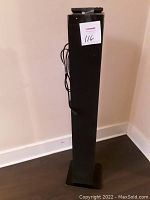 Full view of the Bluetooth tower speaker showing its tall, slim form factor and power cord.