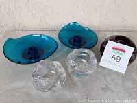 Overall view showing all five candle holders with blue, clear, and purple glass in various shapes and textures.