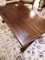 Top view of the rectangular wooden coffee table in closed position showing the slatted wood surface and visible scratches and scuffs.