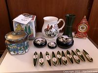 Photo showing vintage Cadbury tin, Chinese enamel box, nesting lacquer boxes, porcelain pitcher, green vase, ornamental clock, and ceramic chopstick rests arranged on a shelf.