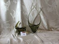 Both glass pieces displayed together on draped fabric background