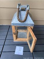 Hurricane lantern viewed from the front with door open showing interior space and latch.