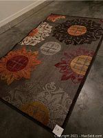 Full view of the outdoor rug laid on the floor showing overall design and condition.