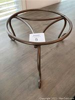 Top view of the bronze metal plant stand showing round frame and inner supporting bars.