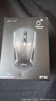 Front of box showing the Akun BT32 Bluetooth Mouse with branding and key features like 10m wireless distance.