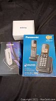 Lot includes Panasonic cordless home phone system in box, Tianhoo mobile phone in box, and Ushining mobile phone box on black background.