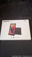 Front view of Dragon Touch K10 tablet packaging showing product image and branding.