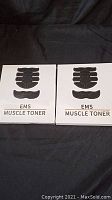 Front view of two EMS Muscle Toner boxes showing the black electrode pad designs on white packaging.