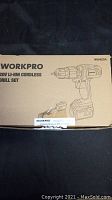 Closed cardboard box with printed label showing Workpro 20V Li-ion cordless drill set.