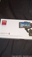 Box showing Zhiyun Smooth 4 branding, partial product image with smartphone mounted.