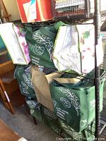 Photo of green reusable bags filled with books on metal shelving
