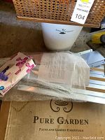 Photo showing the white Urban Composter compost bin and metal raised garden bed parts wrapped in bubble wrap with Pure Garden branding on box