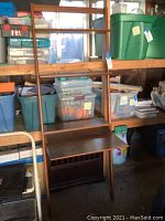 Full view of the leaning desk shelf in a storage area, showing the desk surface and upper shelves