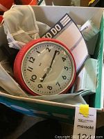 Box with wall clock, notepads to-do lists, and some smaller items.