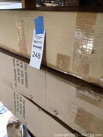 Two large boxes stacked on top of each other with shipping labels and auction tag visible.