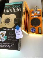 Play Today Ukulele Complete Kit box showing contents and package condition with a fabric-covered box containing calligraphy set items.