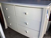 Front view of white 6 drawer dresser showing all drawers and knobs