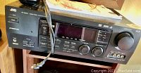 Front view of JVC RX-9000VBK audio/video control receiver showing controls, display, inputs, and power cord.