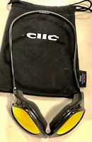 Clic ski glasses with yellow lenses on top of black soft drawstring case