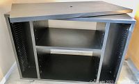 Black swivel stand with shelves and open sides, photo to show its condition and dimensions.
