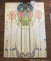Full view of the rug laid flat on hardwood floor showing Art Nouveau style design in pastel colors, symmetrical floral and organic motifs.