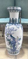 Front view of large vintage Asian porcelain floor vase showing bird perched on branch amid flowers, with flared rim detail