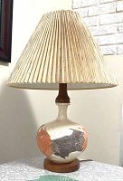 Full view of the mid-century modern table lamp showing the pottery body with abstract Earth Wrap design, teak neck and base, and original beige pleated fiberglass shade.