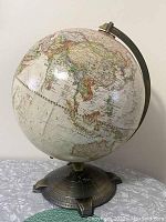 Full globe view showing Asia and Australia from the side with metal stand.