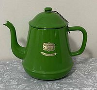 Front view of the vintage green enamel coffee pot with label