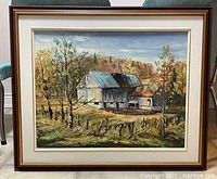 Framed oil painting showing a barn in a rural setting with autumn trees.