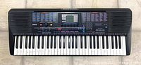 Full front view of Yamaha Portatone PSR-220 electronic keyboard showing 61 keys with some handwritten letters on keys and Yamaha branding on the top center.