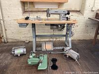 Front view of sewing machine on table with three motors and accessories
