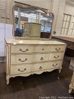 Front view of the French Provincial style dresser with attached mirror showing curved drawer fronts and brass handles.