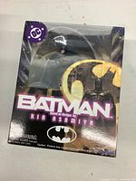 Front view of sealed Batman figurine box showing logo and design credit to Kia Asamiya