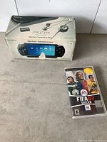Photo showing the Sony PSP original box and FIFA 07 Soccer game case on surface