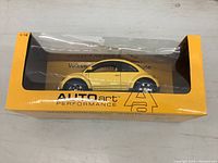 Yellow 1:18 Volkswagen New Beetle Dune model car in original AUTOart Performance packaging, side view