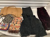 Photo of the full lot showing leather fringe vest, pants, various purses, and patterned fabric