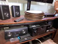 Pioneer VSX-521 receiver and Epic Sound speakers on shelf, including two floor-standing speakers and remote controls.