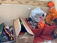 Boxes and bins holding various Halloween decorations including plastic pumpkins and fabric decorations