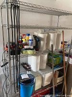 Full view of assembled metal wire shelving rack, contents on shelf not included, showing overall size and wear.