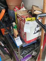 Photo showing Wagner Power Roller box on metal shelving with other items including spray bottle and planters.