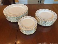 Three stacks of plates: dinner, side, dessert plates arranged on table