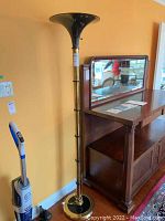 Full view of the standing floor lamp showing its height and lampshade shape, with surrounding furniture.