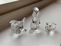 Photo showing all three Swarovski miniature animal figurines: elephant, squirrel, and pig grouped together on white surface.