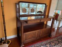 Front view of the vintage wood buffet with mirror showing overall structure, carved pillars, and cabinet doors.