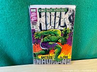 Straight-on shot of full front cover in protective sleeve against green felt background