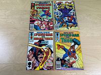 Four Marvel Team-Up comic books displayed on a wooden floor showing full covers.